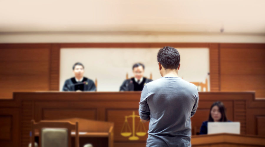 man standing in front of judges | RM Warner Inernet Law Firm