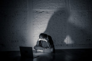 girl crying next to computer | RM Warner Inernet Law Firm