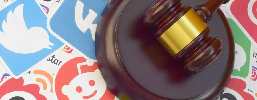wooden gavel surrounded by social media stickers | Will TikTok be Banned in the US? | RM Warner Internet Law Firm | Daniel Warner | Daniel R. Warner | Raees Mohamed