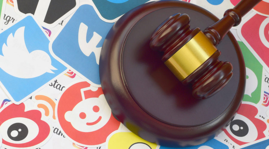 wooden gavel surrounded by social media stickers | RM Warner Inernet Law Firm