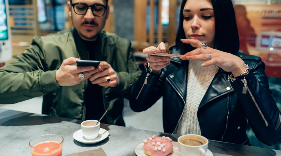 Young couple photographing food with smart phone - social network, sharing, food blogger concept | RM Warner Inernet Law Firm