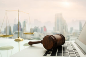 gavel sitting on laptop with weights of justice in the background | RM Warner Internet Law Firm | Public Forum image