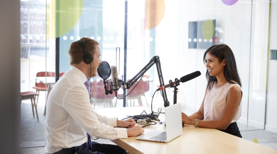 two radio show hosts speaking across from each other in studio | RM Warner Inernet Law Firm
