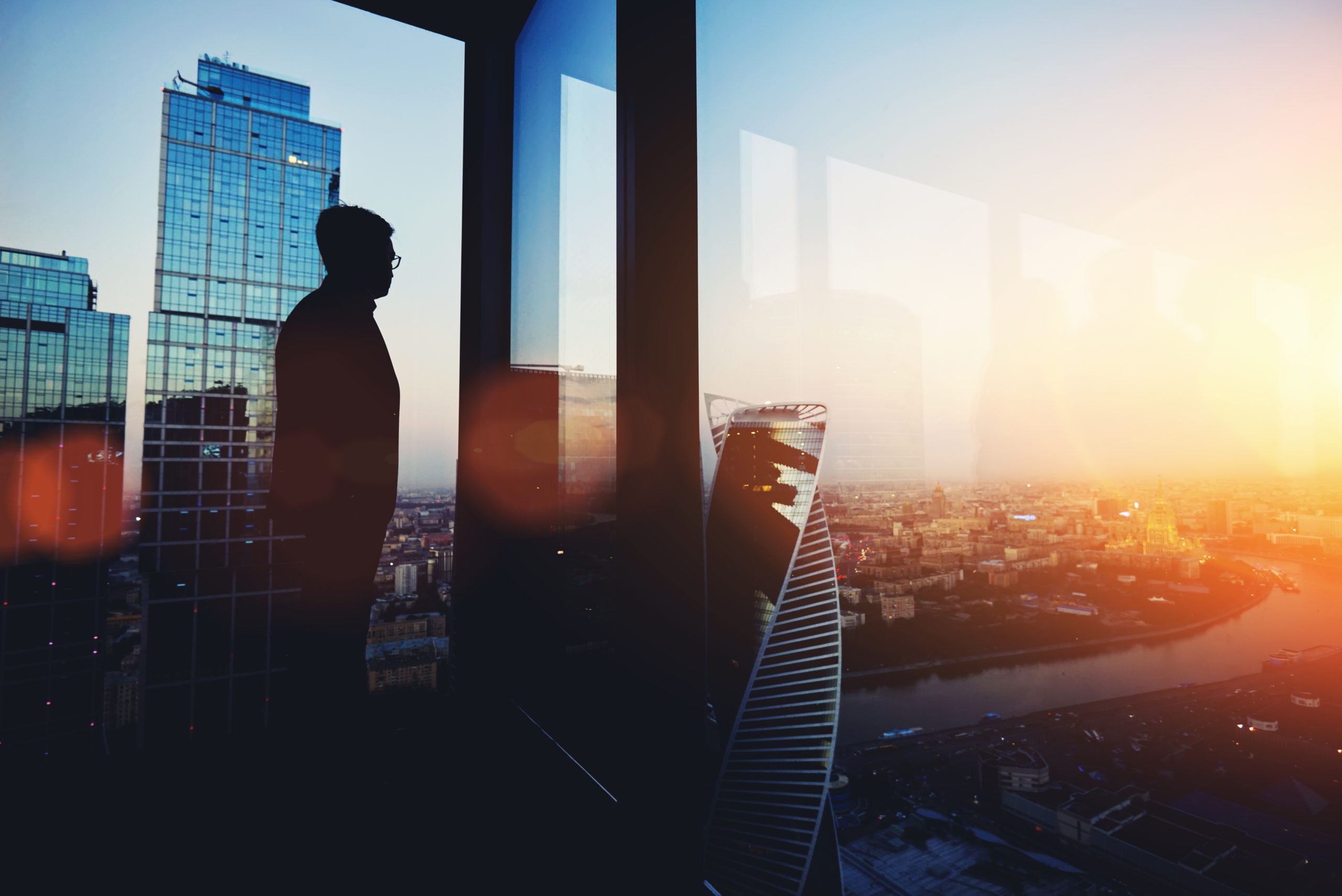 man looking out large window of office building | Jeffrey Epstein | RM Warner Internet Law Firm | Daniel Warner | Daniel R Warner | Raees Mohamed